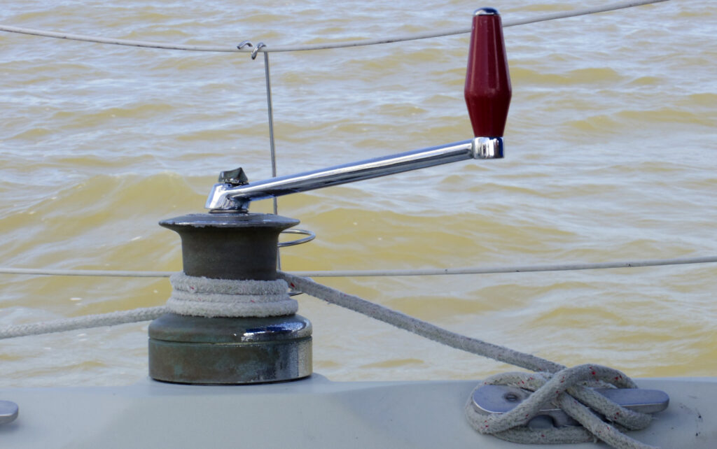 Winch di una barca a vela con una scotta avvolta e la manovella inserita nella sede