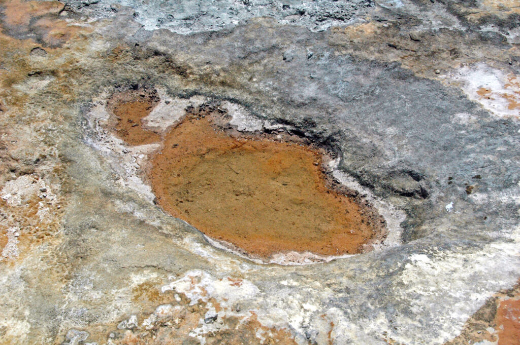 Onde che superano il muretto del lungomare davanti alle vetrine di un locale chiuso
