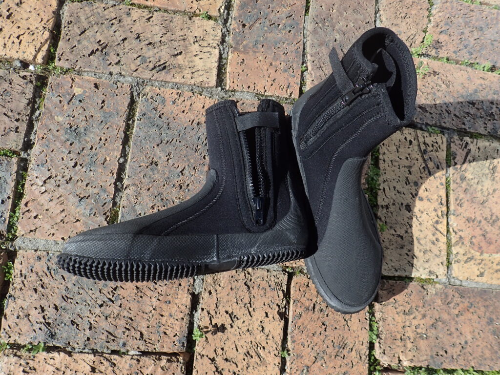 Calzari in neoprene su uno scoglio bagnato vicino all'ingresso in acqua